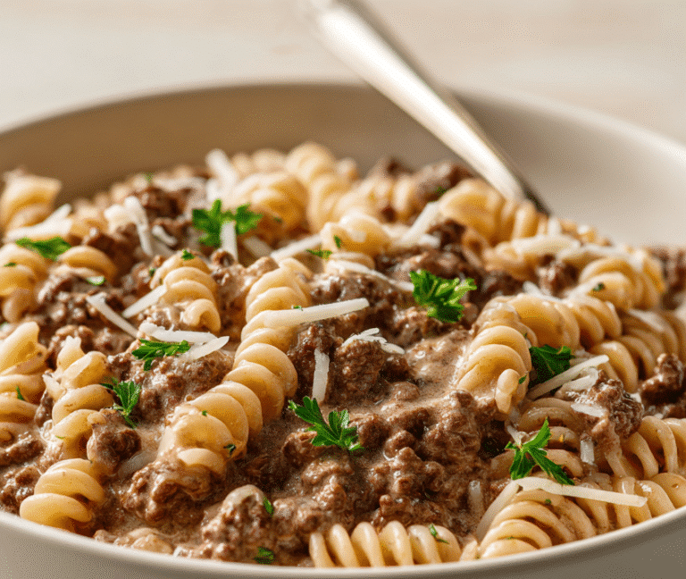 Bowl of high protein creamy beef pasta topped with parsley